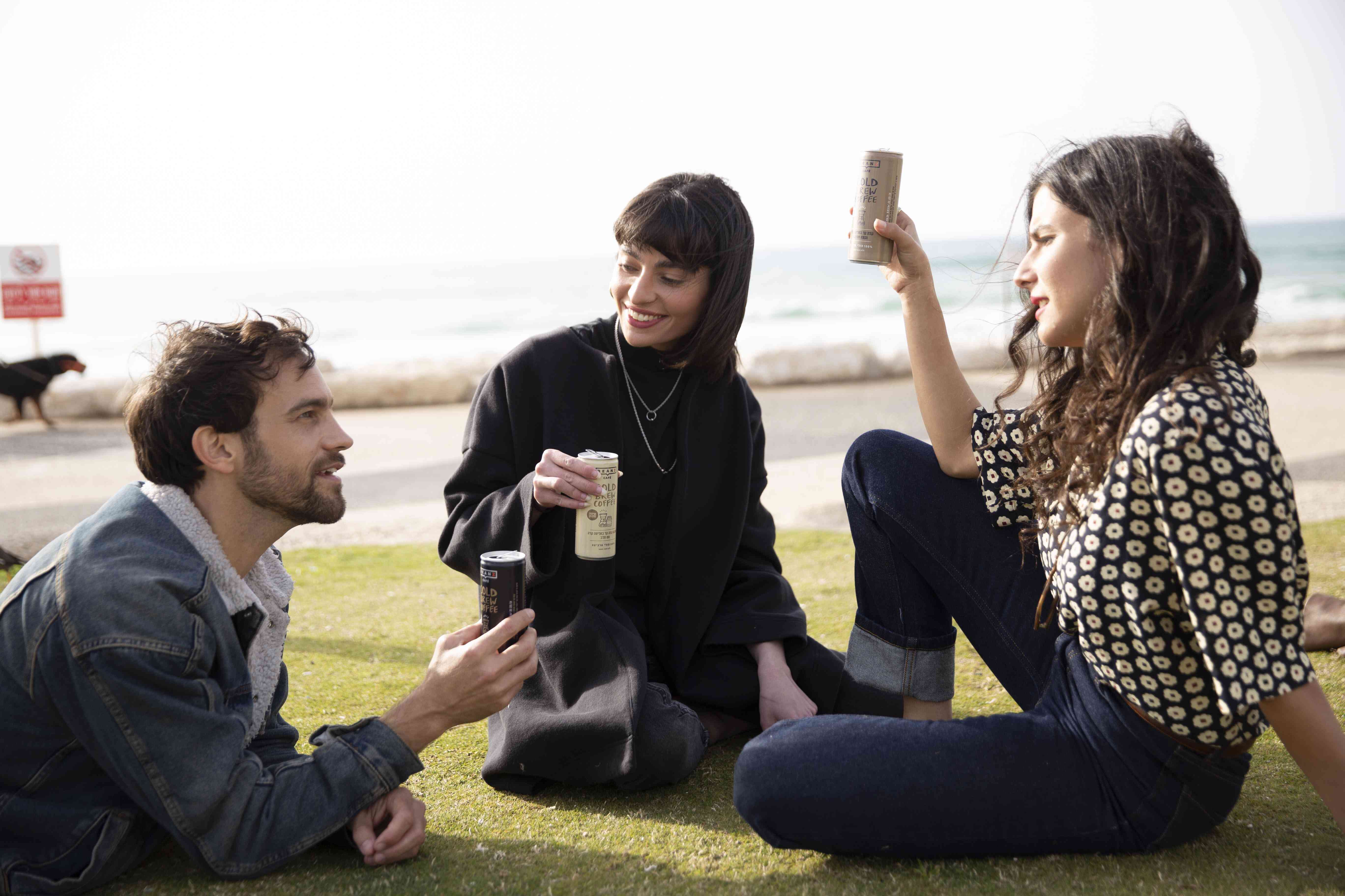 שלושה שותים קפה בים